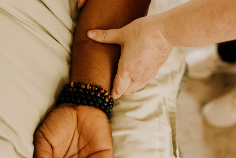 Therapist's hands holding a client's arm, demonstrating a calming and supportive touch.