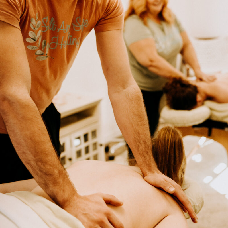 Two massage therapists working on clients