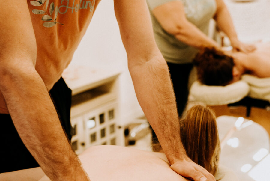 Two massage therapists working on clients