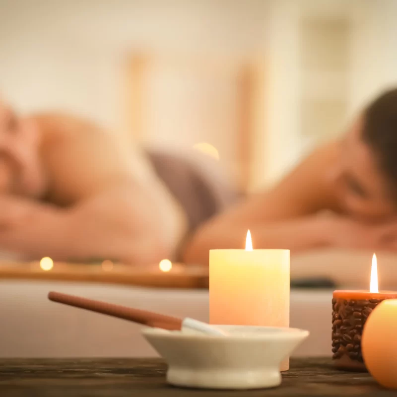 Relaxing spa scene with candles and couples massage