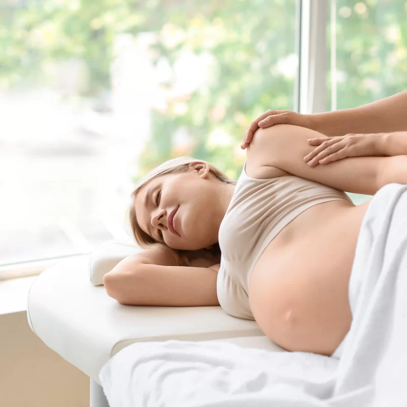 Pregnant woman receiving prenatal massage services.