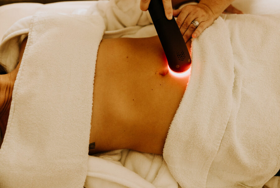 Laser therapy on patient's abdomen in spa setting.