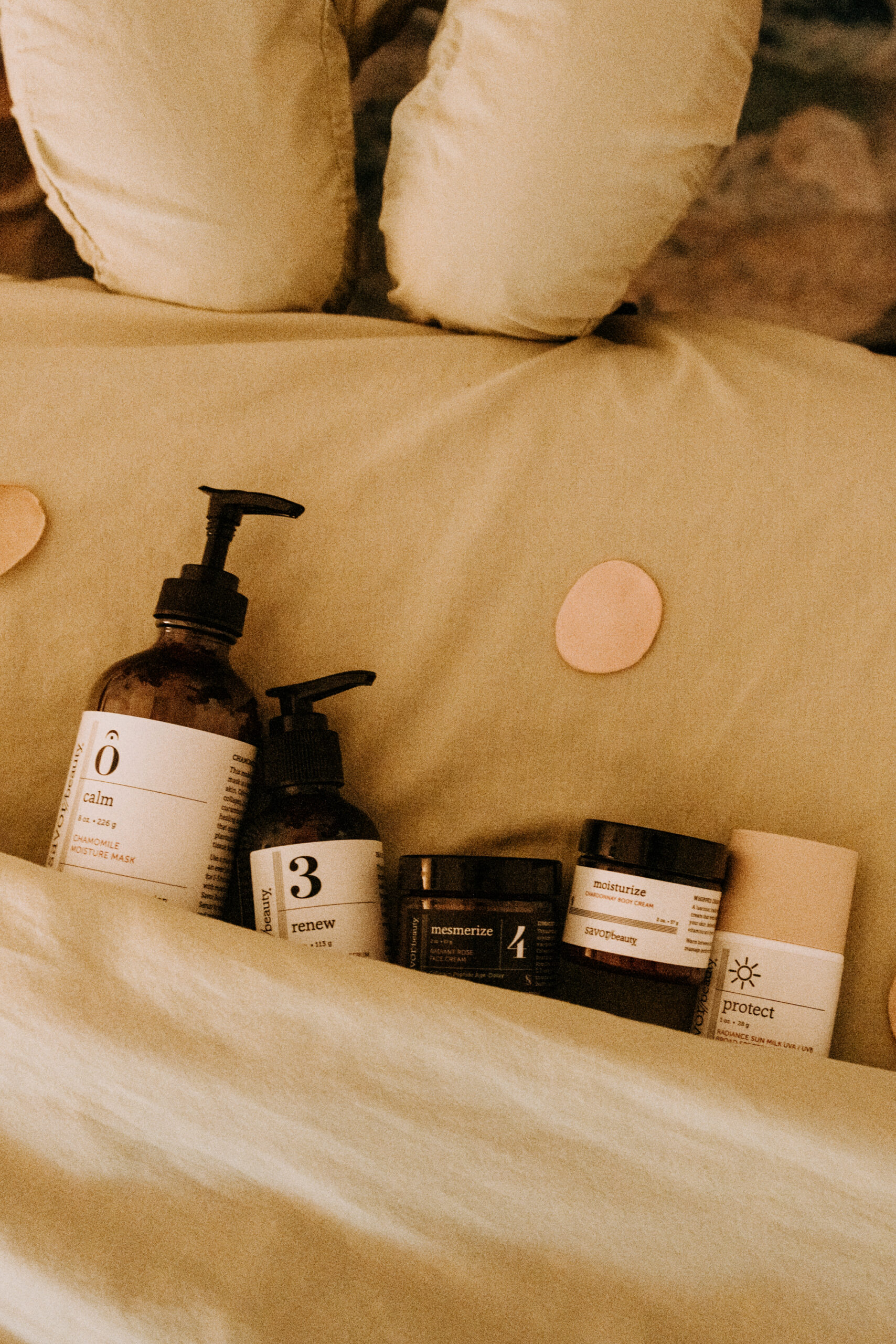 Skincare products arranged on a bed.
